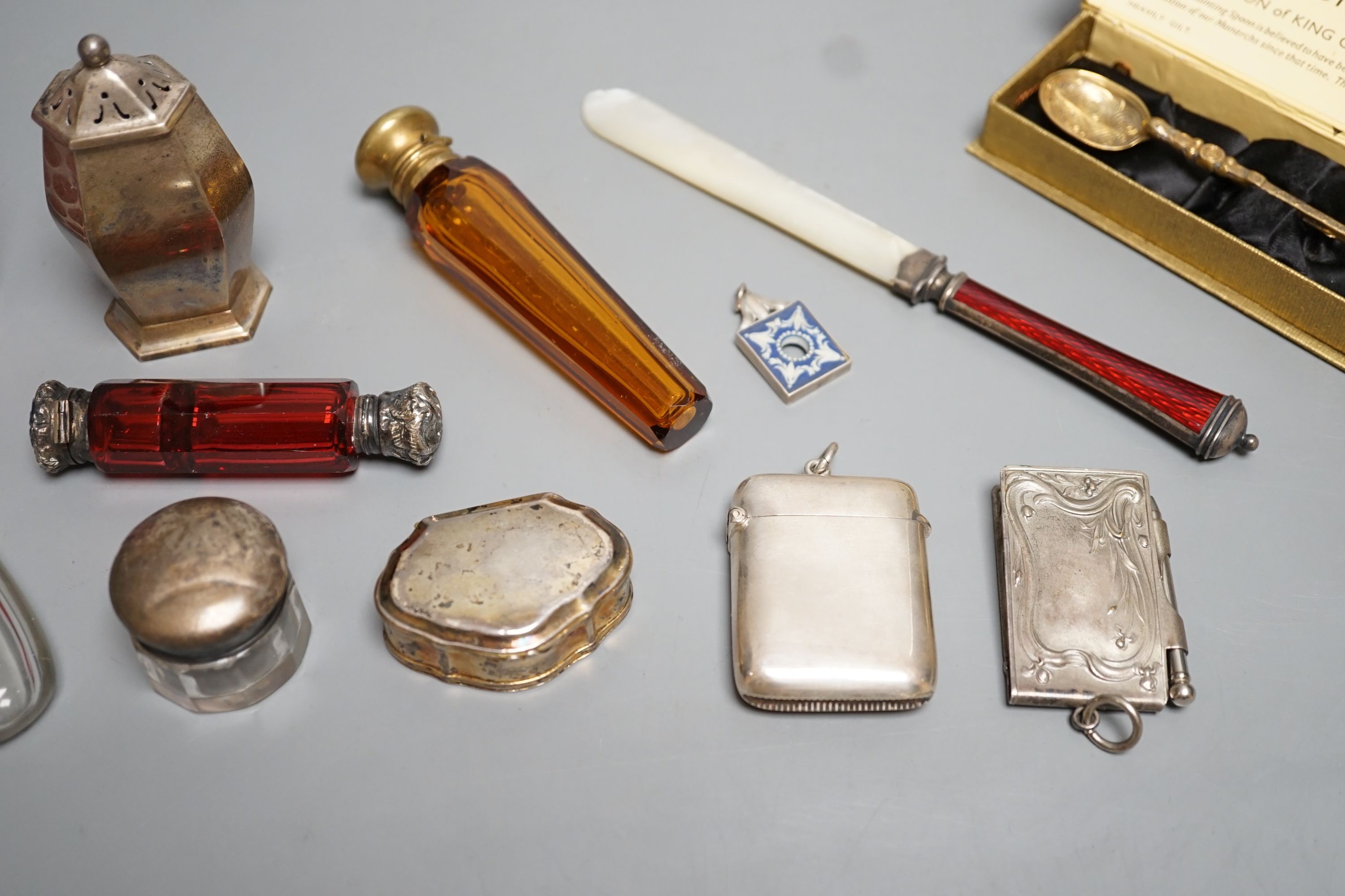 Four assorted white of gilt metal mounted glass scent bottles, largest 12.2cm, an unusual gilt white metal snuff box?, with spoon, a sterling and enamel mounted mother of pearl paper knife and other minor items.
